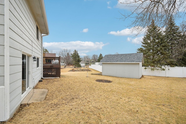 view of yard featuring a fenced backyard, a storage unit, a deck, and an outdoor structure