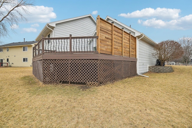 rear view of house featuring a lawn and a wooden deck