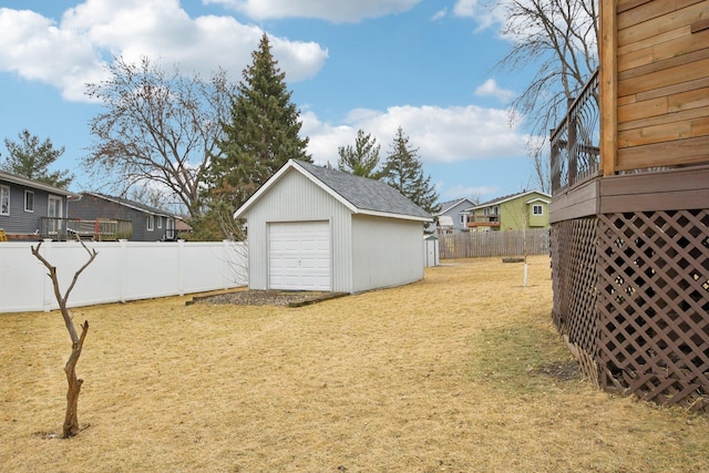 view of yard with an outbuilding, a fenced backyard, and a garage