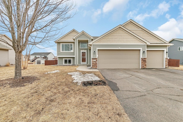 view of front of house featuring aphalt driveway, fence, and a garage