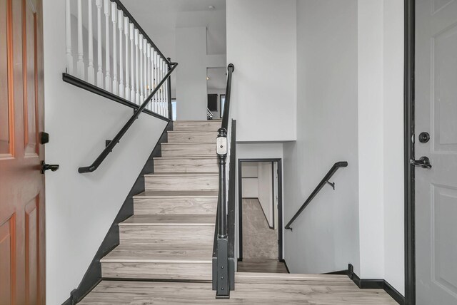 staircase with baseboards and wood finished floors