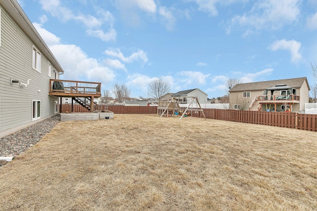 view of yard with stairway, a playground, a fenced backyard, and a wooden deck