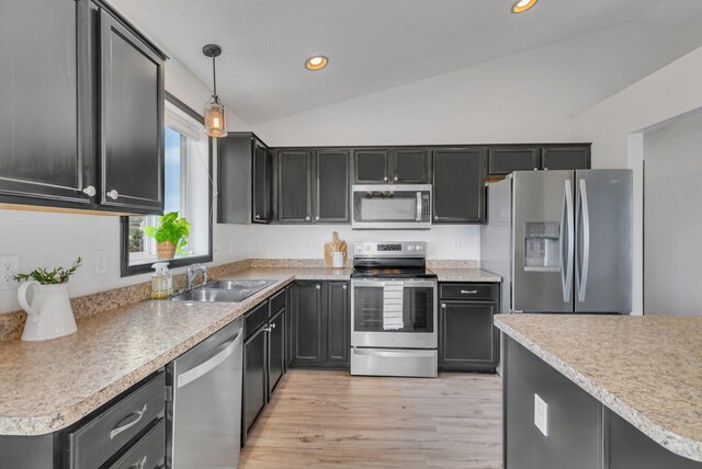 kitchen featuring vaulted ceiling, stainless steel appliances, pendant lighting, a sink, and recessed lighting