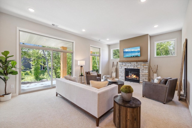 living area featuring a fireplace, visible vents, light colored carpet, and recessed lighting