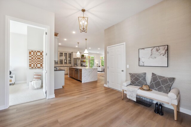 entryway featuring light wood finished floors, baseboards, an inviting chandelier, and recessed lighting