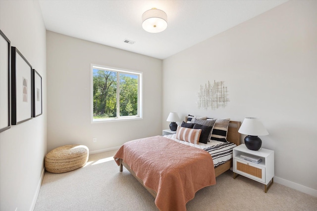 bedroom featuring visible vents, baseboards, and light carpet