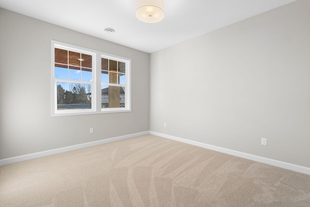 empty room with light carpet, visible vents, and baseboards