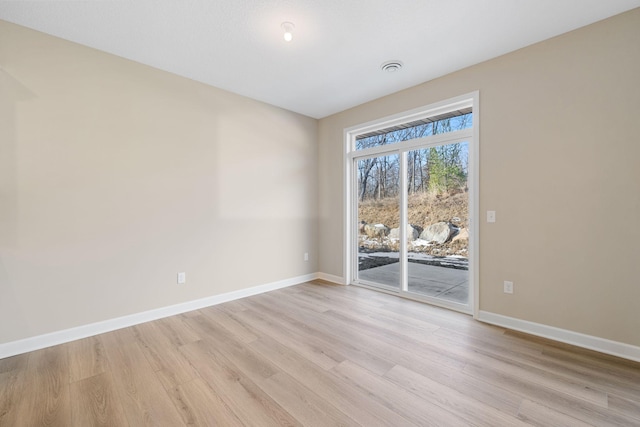 unfurnished room with light wood-type flooring and baseboards