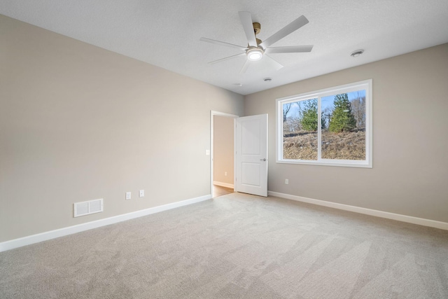 spare room featuring a ceiling fan, carpet flooring, visible vents, and baseboards