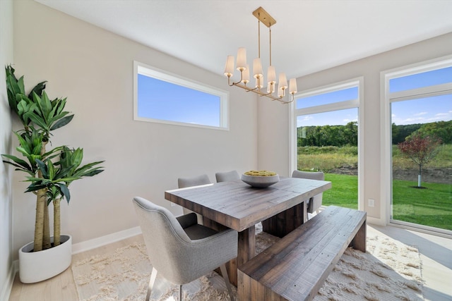 dining room with baseboards, a wealth of natural light, and an inviting chandelier