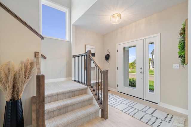 foyer with stairway, wood finished floors, and baseboards