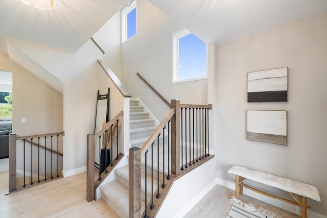 staircase with wood finished floors and baseboards