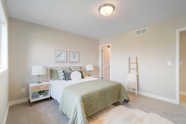 carpeted bedroom featuring visible vents and baseboards