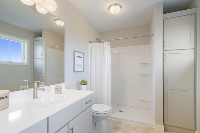 full bathroom featuring toilet, a stall shower, and vanity