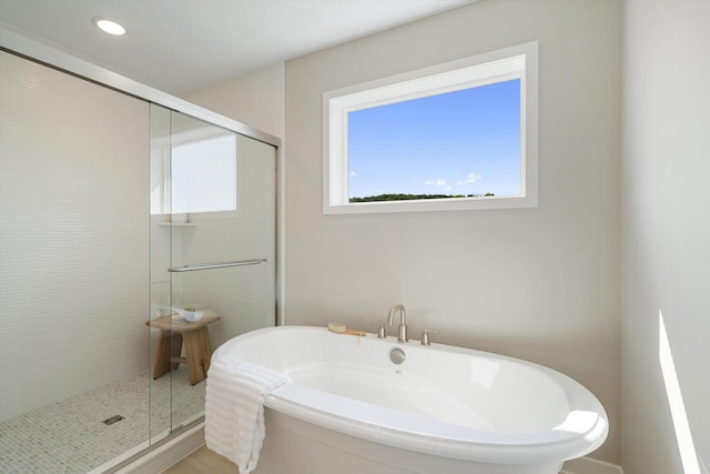 full bath with a stall shower, a freestanding tub, and recessed lighting