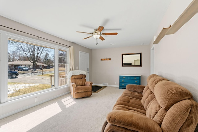 living area with carpet flooring, a ceiling fan, baseboards, and visible vents