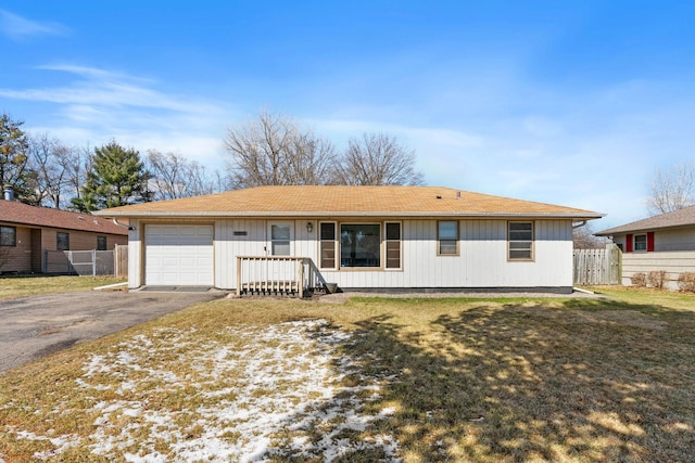 ranch-style house featuring fence, an attached garage, and aphalt driveway