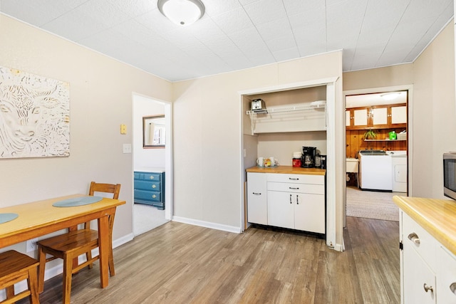 dining space featuring washing machine and dryer and light wood-type flooring