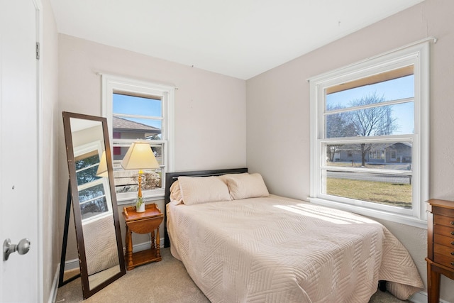 bedroom with multiple windows and light carpet