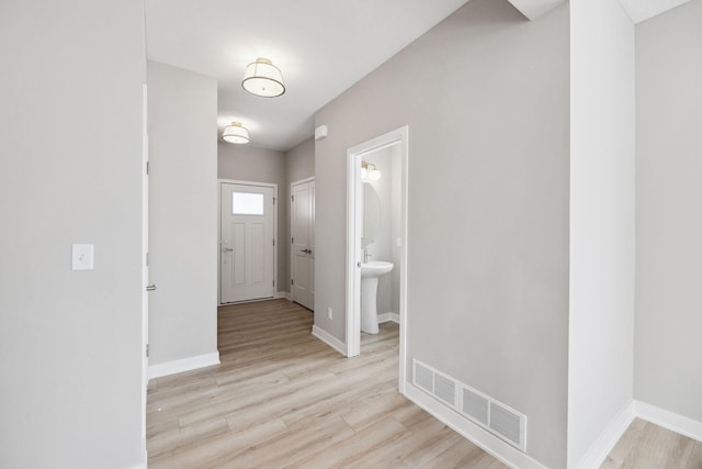 entryway with light wood-type flooring, visible vents, and baseboards