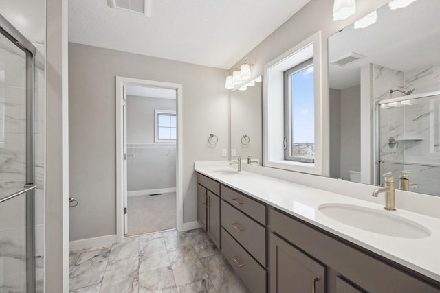 bathroom featuring marble finish floor, visible vents, a sink, and a marble finish shower