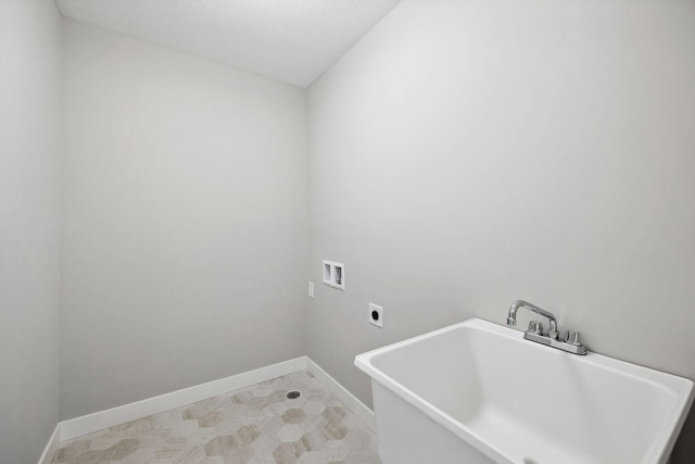 laundry area with hookup for a washing machine, hookup for an electric dryer, a sink, laundry area, and baseboards