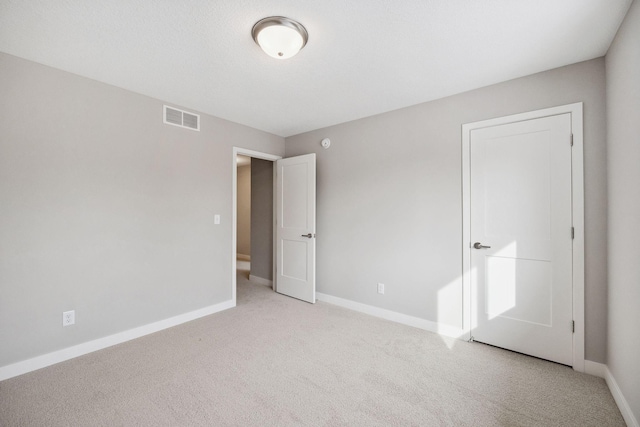 unfurnished bedroom with light carpet, baseboards, and visible vents