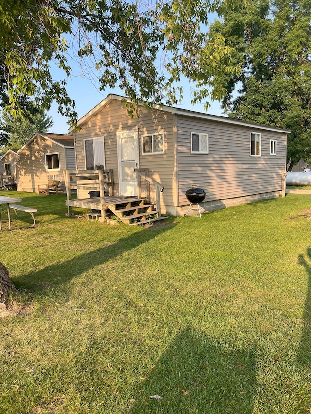 back of property featuring a lawn and a wooden deck