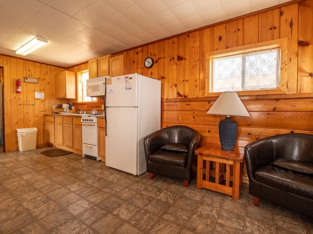 kitchen with dark floors, white appliances, light countertops, and wooden walls