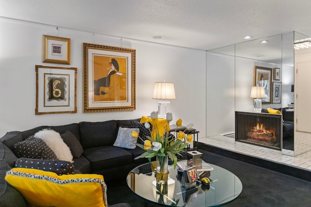 living area with a textured ceiling, a tiled fireplace, and recessed lighting