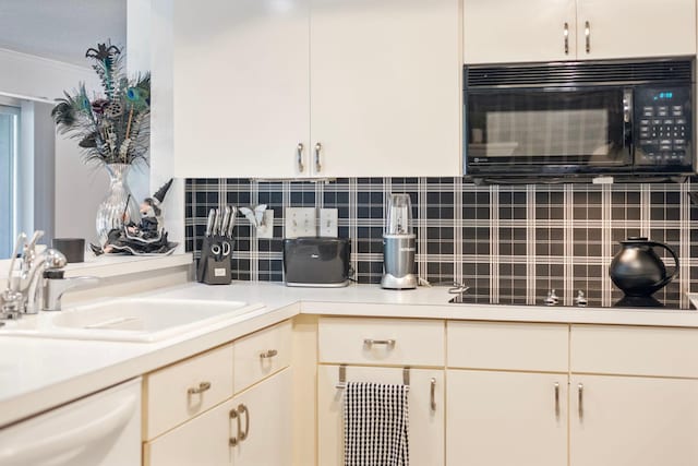 kitchen with decorative backsplash, dishwasher, light countertops, black microwave, and a sink