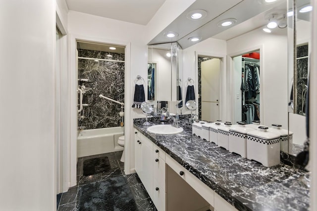 full bath with shower / bathtub combination, toilet, vanity, marble finish floor, and a spacious closet