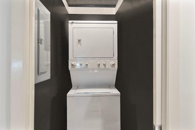 washroom with laundry area, electric panel, and stacked washer and clothes dryer