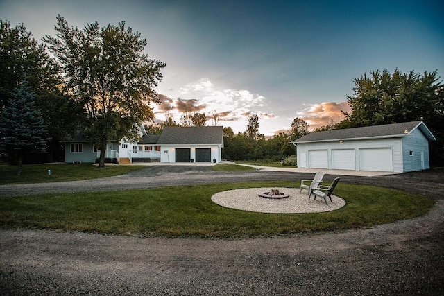 garage at dusk with a yard and a garage