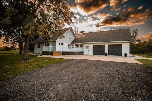 view of front facade with a front yard, concrete driveway, an attached garage, and a shingled roof