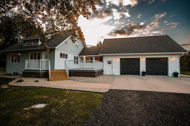 view of front of house with an attached garage, concrete driveway, and a shingled roof