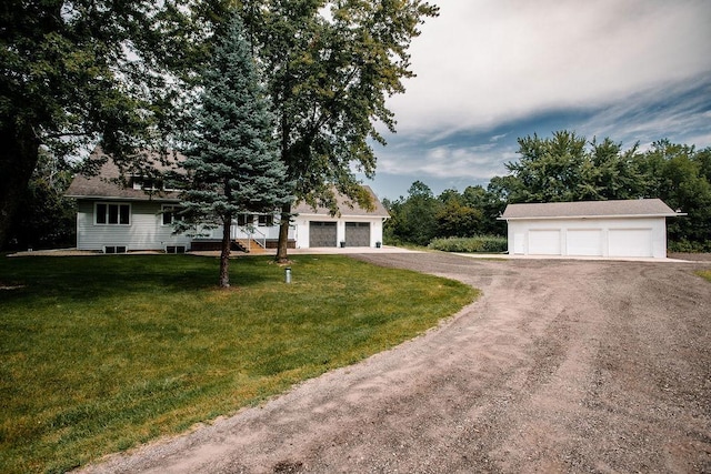 view of front of property featuring a front lawn, a garage, and an outdoor structure