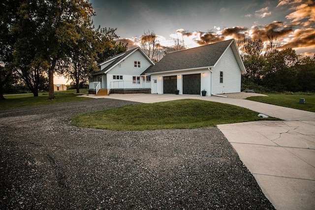 view of side of home with a lawn, an attached garage, and driveway