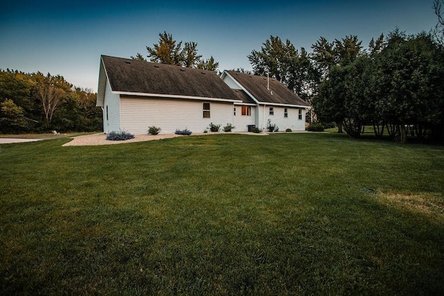 rear view of house featuring a lawn