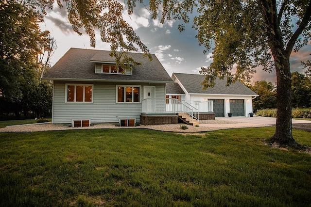 back of house with a lawn, concrete driveway, a shingled roof, a garage, and central AC unit