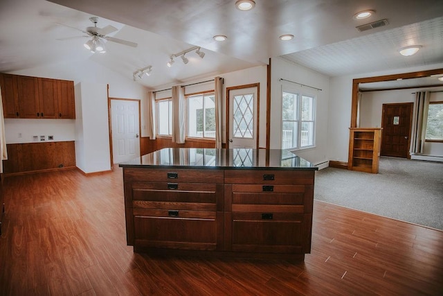 kitchen with visible vents, lofted ceiling, dark countertops, and dark wood-type flooring