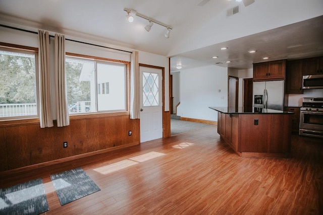 kitchen featuring visible vents, lofted ceiling, light wood-style flooring, stainless steel appliances, and dark countertops