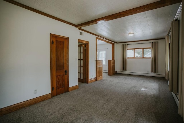 carpeted spare room with visible vents, crown molding, a baseboard heating unit, and baseboards