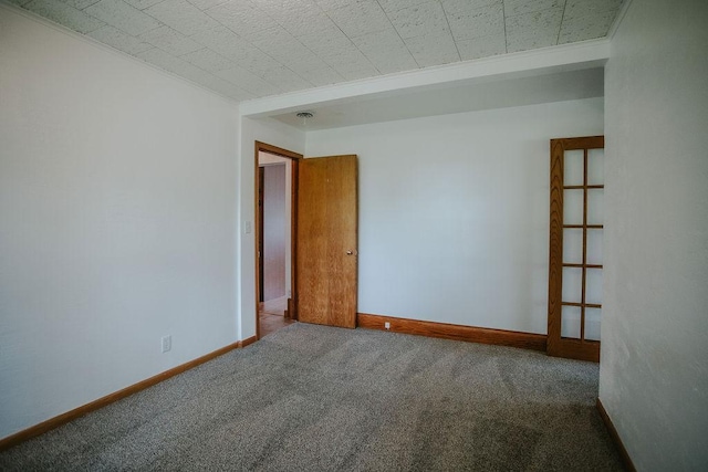 spare room featuring baseboards and carpet