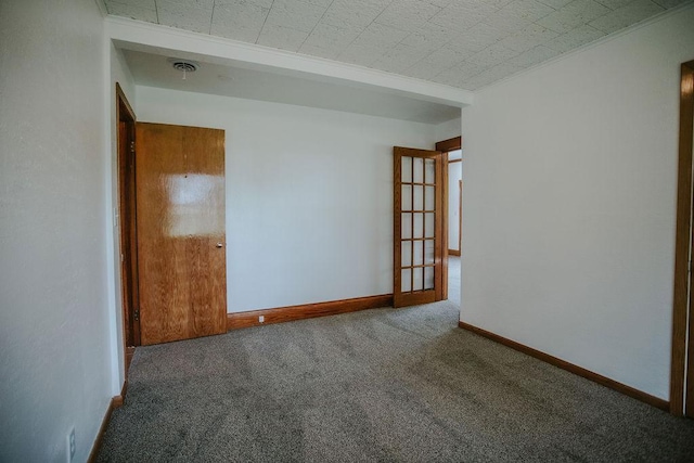 unfurnished room with carpet flooring, visible vents, and baseboards