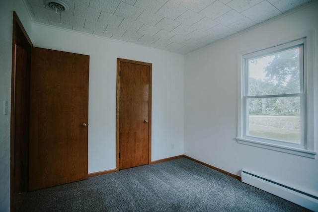 unfurnished bedroom featuring visible vents, carpet, crown molding, a baseboard radiator, and baseboards