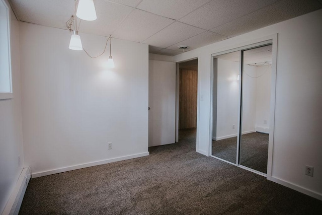 interior space featuring visible vents, baseboards, a drop ceiling, carpet floors, and baseboard heating