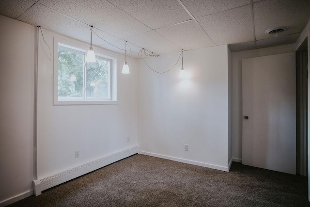 basement featuring dark colored carpet, a baseboard heating unit, a drop ceiling, and visible vents