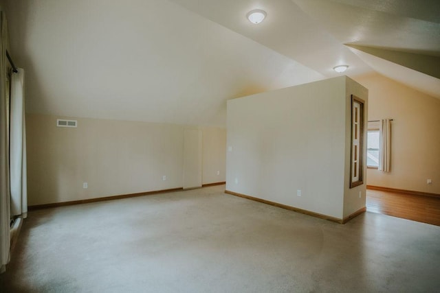 additional living space featuring visible vents, baseboards, carpet floors, and vaulted ceiling