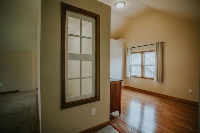 additional living space with lofted ceiling, wood finished floors, and baseboards